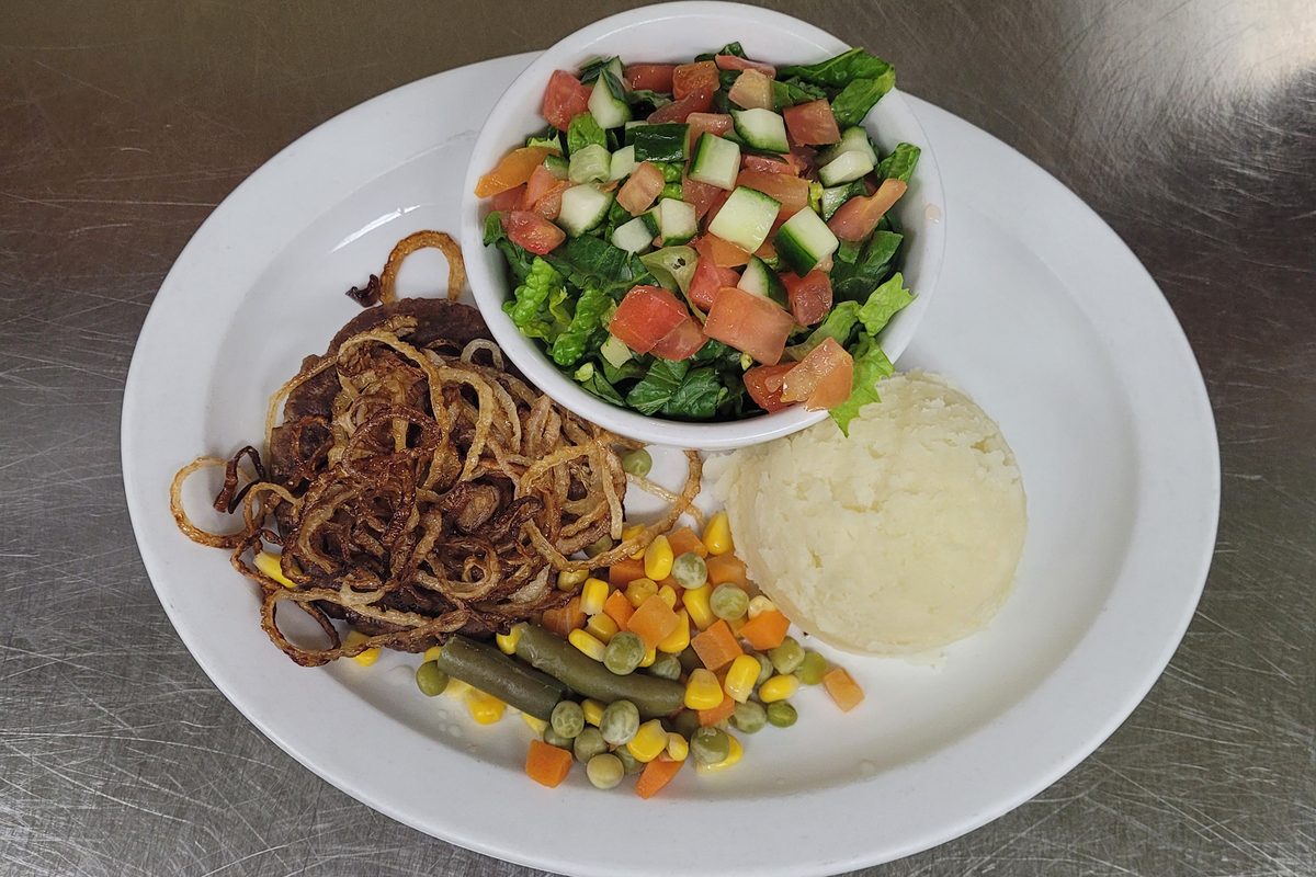 Hamburger steak with fried onions, mashed potato and salad